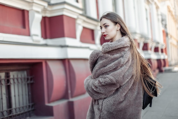 Foto moda donna in una lussuosa pelliccia che cammina in città