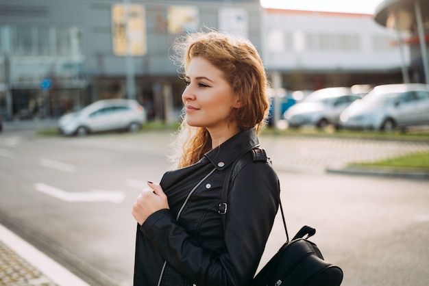 Fashion woman portrait of young pretty trendy girl posing at the city street.