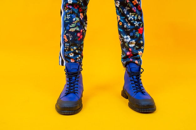 Fashion woman's legs in colorful pants and blue boots