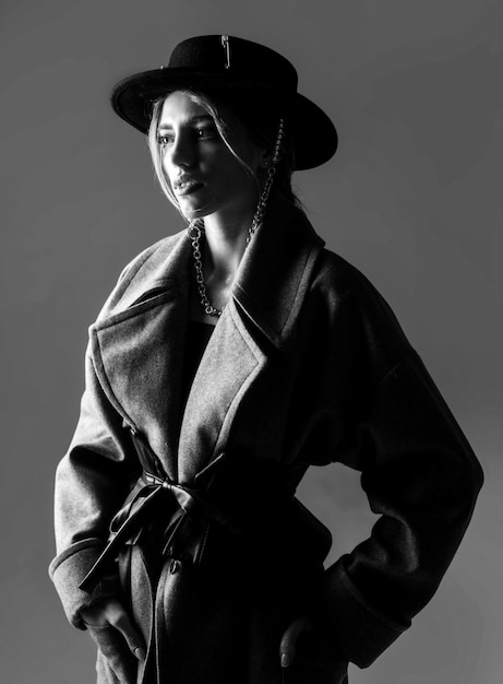 グラマー官能的な若いスタイリッシュな女性weariの黒い丸い帽子のファッションの肖像画を身に着けているファッションの女性