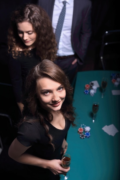 Moda donna con bicchieri di vino seduto a un tavolo in un casinò