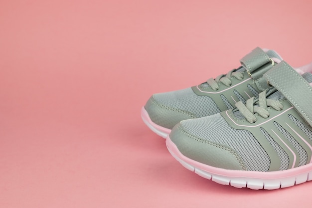 Fashion women's sneakers gray and pink on a pastel background. Sports shoes.