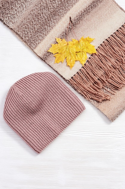 Fashion wool warm scarf and handmade knitted cap cozy autumn female clothing decorated autumn leaves