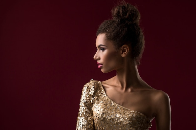 Fashion young african woman with makeup in sexy gold dress