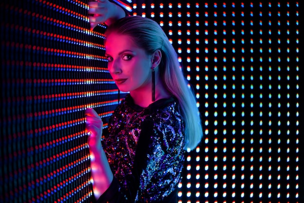 Fashion young elegant woman. Colored neon background, studio shot.