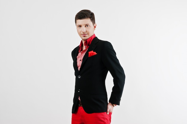 Fashion young man in black suit and red pants casual poses 