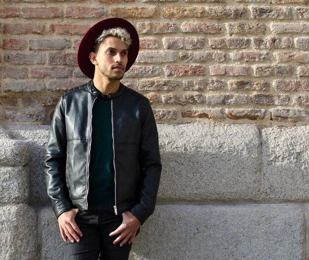 Fashion young model with leather jacket and red hat in the street