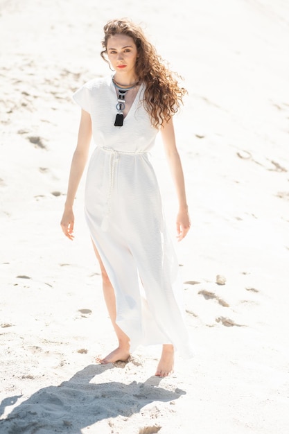 白いシャツのビーチでファッションの若い女性