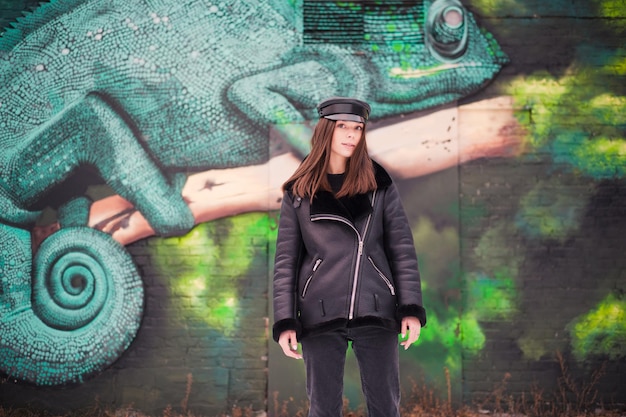 Fashion young woman in leather jacket and cap