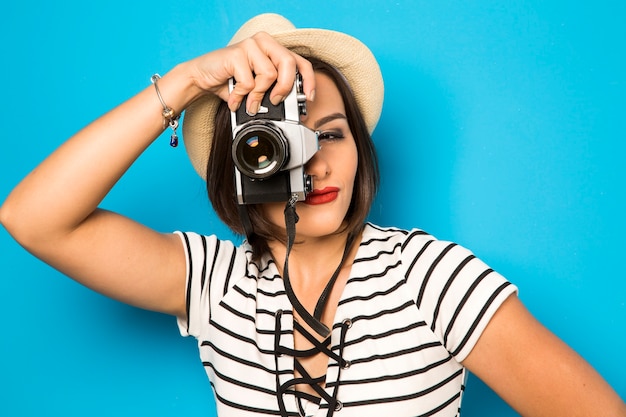 Fashion young woman makes the photo with old camera