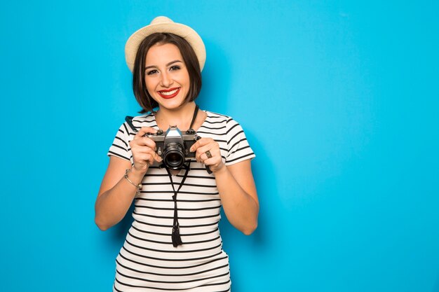 Fashion young woman makes the photo with old camera