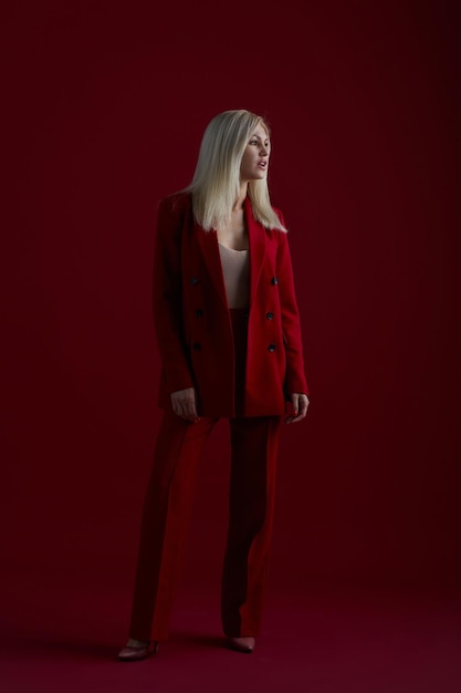 Fashion young woman in red suit red background