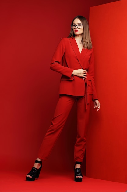 赤いスーツのファッションの若い女性