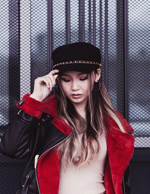 Fashionable asian model woman in hat posing in street