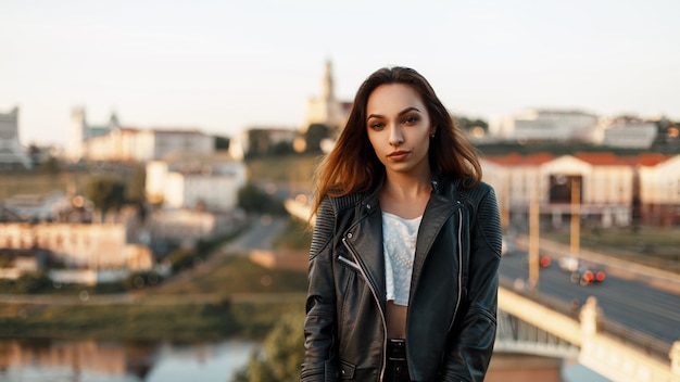 Fashionable beautiful woman in a black jacket on a summer day