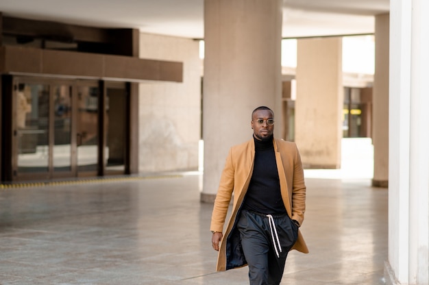 Uomo di colore alla moda che cammina in città