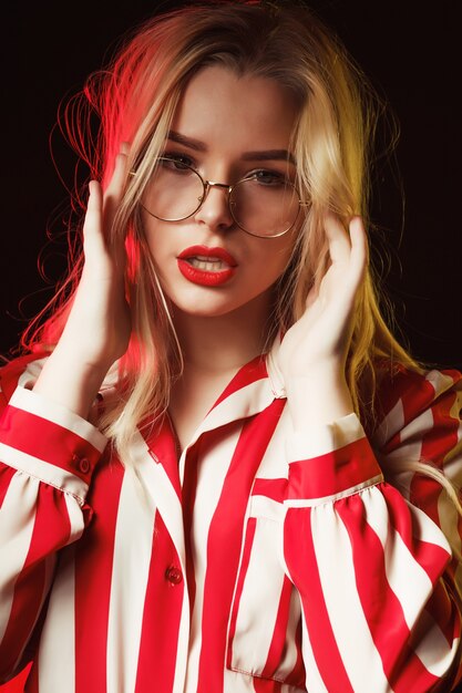 Fashionable blonde girl in glasses wearing striped blouse