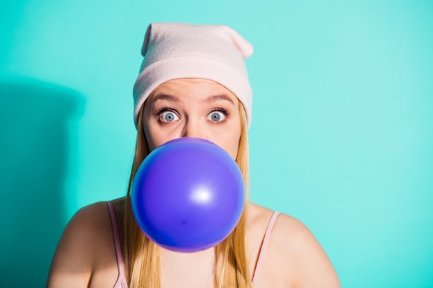 Fashionable blonde woman posing against the blue wall