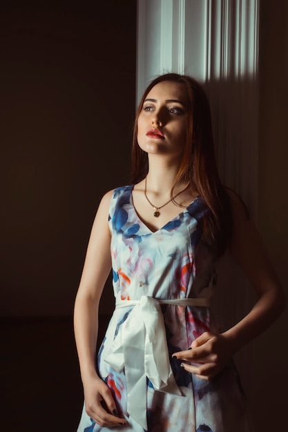 Fashionable brunette woman posing in the dark room