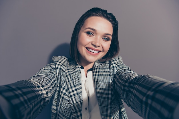 Fashionable businesswoman wearing a checkered blazer posing indoors