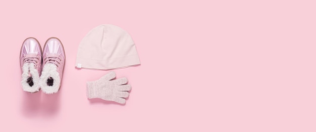 Photo fashionable children's boots a hat and gloves for a girl on a pink background top view flat lay banner