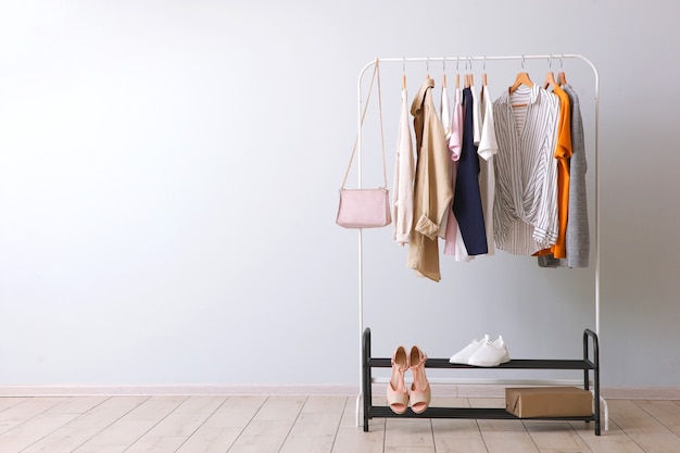 Fashionable clothes on a rack in the interior of a bright room