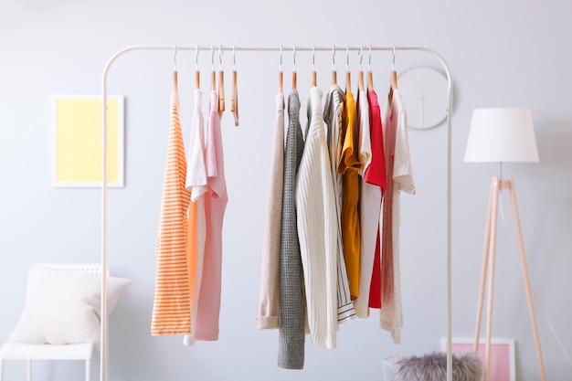 Fashionable clothes on a rack in the interior of a bright room