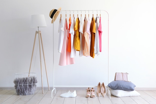 Fashionable clothes on a rack in the interior of a bright room