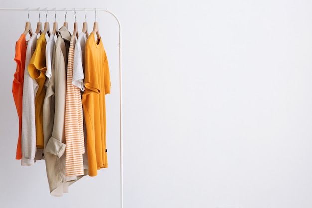 Fashionable clothes on a rack in the interior of a bright room