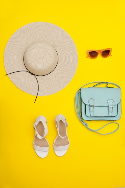 Fashionable concept. Female beach hat, handbag, white shoes.