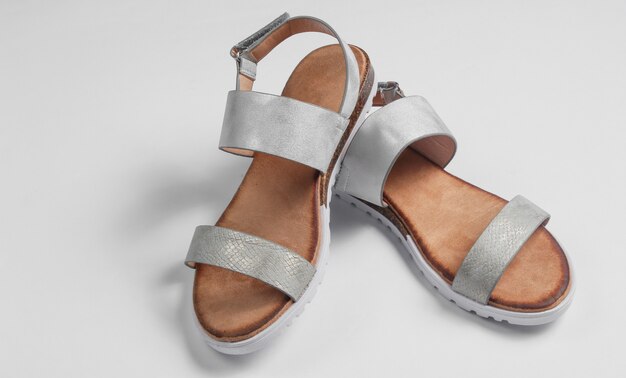 Fashionable female sandals on white close-up