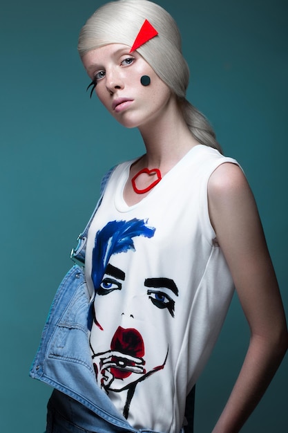 Fashionable girl: natural make-up, clothes with picture in style of pop art. Creative image.