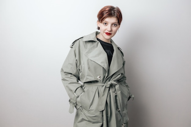 A fashionable girl poses in a spring coat