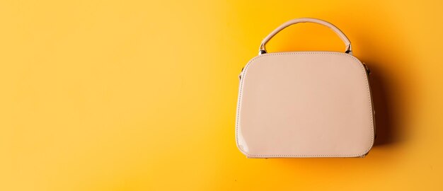 Fashionable leather bag on yellow background. shopping store concept. female leather stylish bag. fashion accessory. copy space.