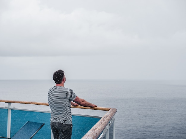 Fashionable man on the empty deck of a cruise liner