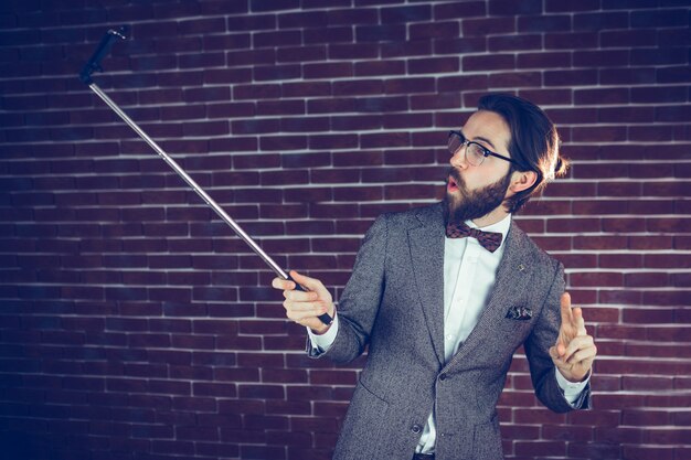 Fashionable man taking selfie through smartphone