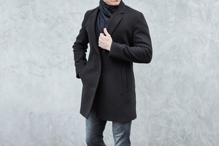 Photo 都市環境で黒いコートとジーンズを着たファッショナブルな男性