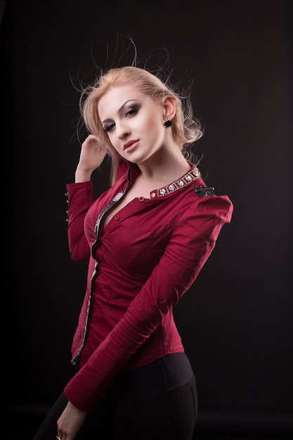 Fashionable model with hair in motion on dark studio background