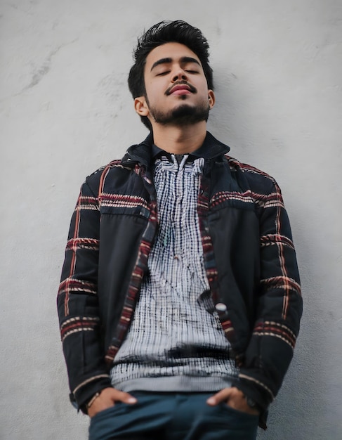 Fashionable person in coat standing on white wall streetwear concept