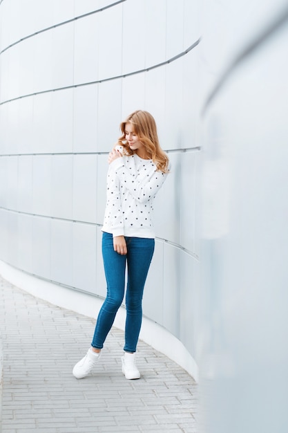 Fashionable pretty woman on the background of modern light wall