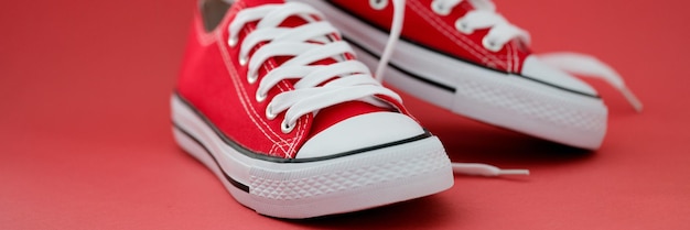 Fashionable red sports sneakers with white laces closeup