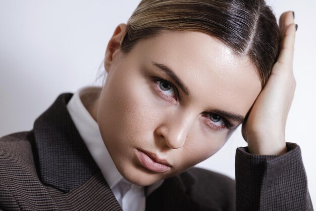 Fashionable studio portrait of young masculine woman against white background