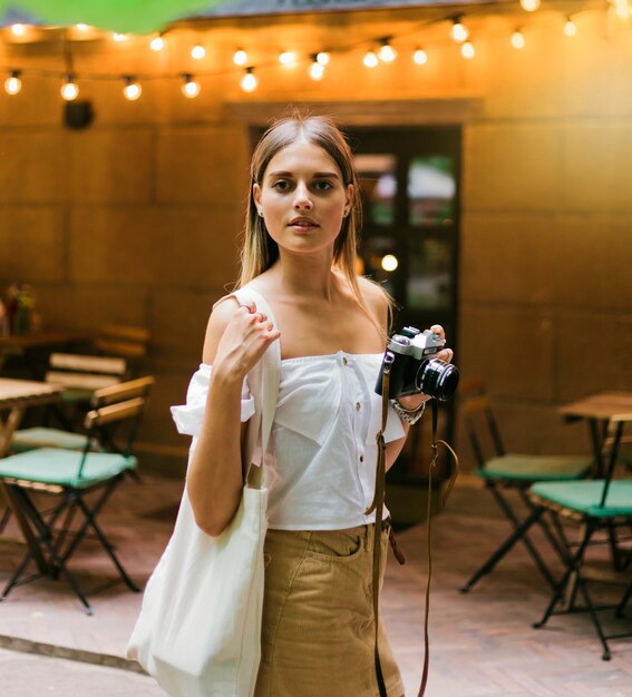 Fashionable stylish woman in trendy clothes and sunglasses posing outdoors