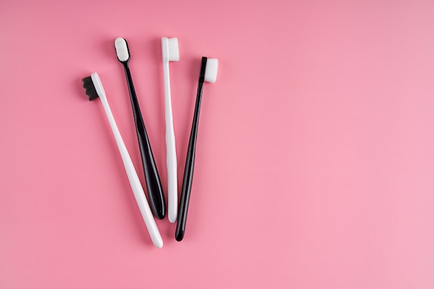 やわらかい毛のファッショナブルな歯ブラシ。人気の歯ブラシ。衛生動向。ピンクの表面に歯ブラシのキット。