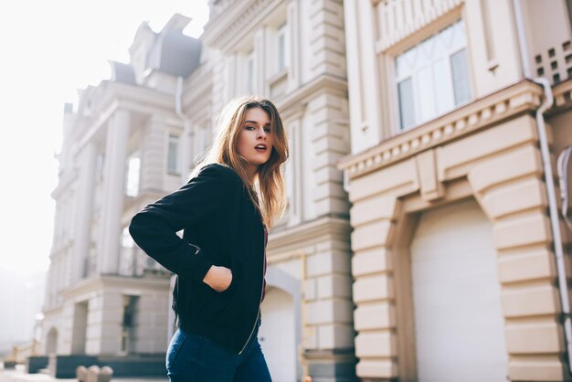 Fashionable urban cloth style portrait with attractive woman in black jacket and looking at camera