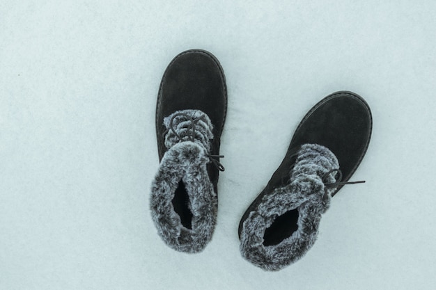 눈 덮인 배경에 세련된 따뜻한 여성용 신발. 아름답고 실용적인 여성용 겨울 신발.