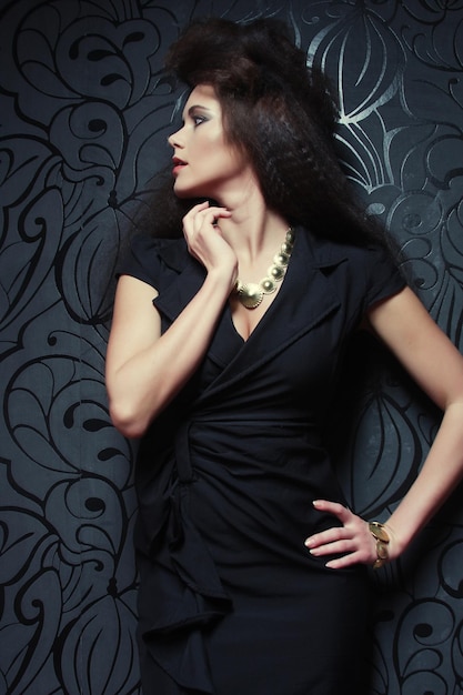 Fashionable woman in black dress Studio shot