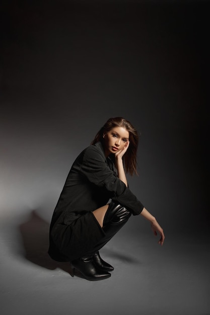 fashionable woman in black leather boots and black jacket portrait long hair beauty beautiful eyes
