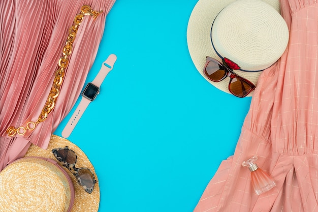 Fashionable woman clothes flatlay on blue background