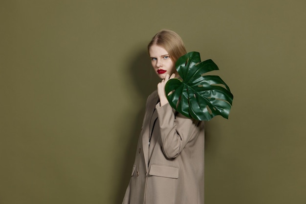 Фото Модная женщина зеленый пальмовый лист пальто яркий макияж студия модель неизмененная фото высокого качества